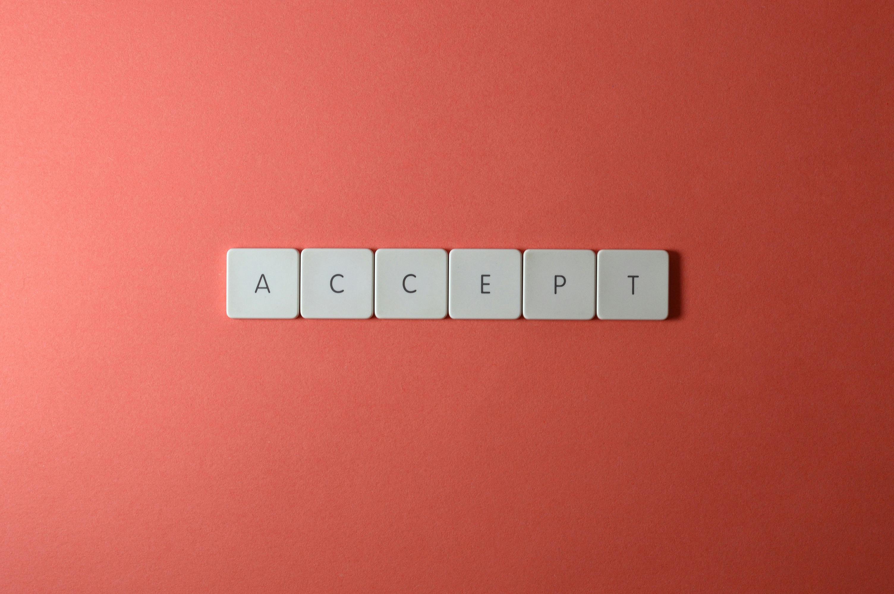 Close-up of keyboard keys spelling 'ACCEPT' on a red background, creating a minimalist and modern design.