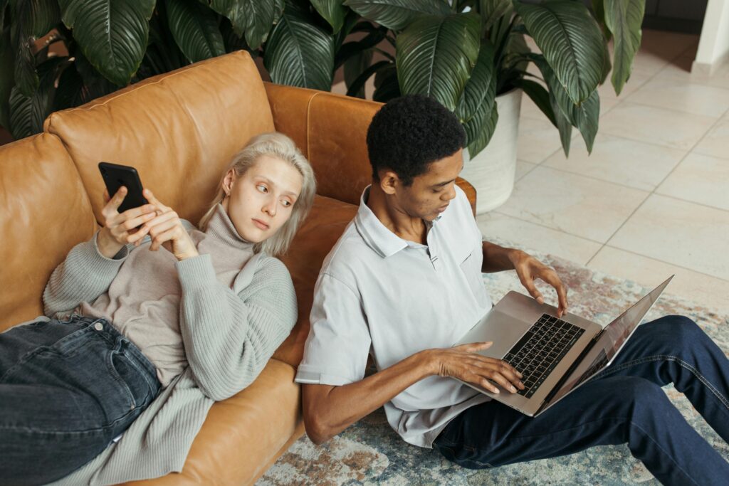 Two colleagues collaborating at a startup, using devices in a relaxed office setting.